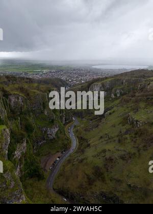 Vue spectaculaire sur une route sinueuse serpentant à travers une falaise majestueuse sous un ciel orageux Banque D'Images