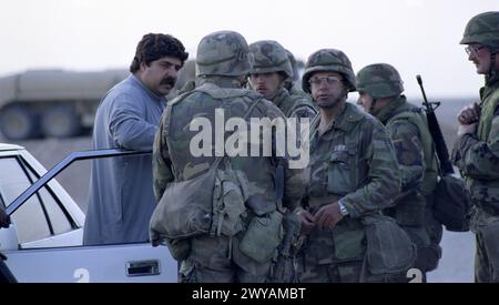 Première Guerre du Golfe : 26 mars 1991 des soldats de l'armée américaine parlent avec un homme local au dernier poste de contrôle américain, à seulement 8 km au sud de Nasiriyah dans le sud de l'Irak. Banque D'Images