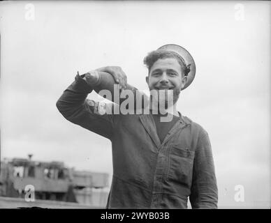 Un marin sur le HMS Repulse lors de son réaménagement de 1940, connu sous le nom de « Bearded Gunner », est photographié épaulant une coquille de 4 pouces. Banque D'Images