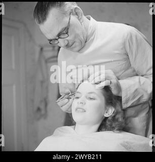 NAISSANCE D'UNE ÉTOILE : LA VIE QUOTIDIENNE DE L'ACTRICE MURIEL PAVLOW, ANGLETERRE, Royaume-Uni, 1945 - le maquilleur Bob Clark épaisse les sourcils de l'actrice Muriel Pavlow, assise dans la chaise de salle de maquillage des Welwyn Garden Studios dans le Hertfordshire. Selon la légende originale, M. Clark "dit que du point de vue du maquillage, elle a souvent l'air trop jeune, doit ajouter quelques lignes pour l'âge". , Banque D'Images