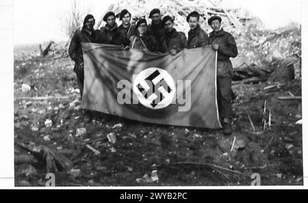 Le personnel du QG de la 1re brigade de Commando tient un drapeau nazi capturé dans un quartier général allemand à Wesel pendant l'assaut du Rhin, où un général allemand a été tué et deux colonels capturés. Banque D'Images