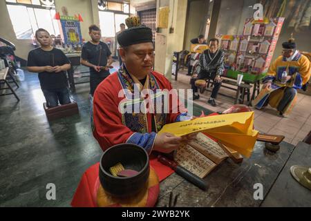 Un chaman traditionnel exécutant un rituel avec des offrandes aux ancêtres sur un autel dans le temple Donggyue Hall Banque D'Images