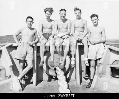 AVEC LA FLOTTE BRITANNIQUE DES INDES ORIENTALES. JUIN 1945, À BORD DU HMS EMPRESS, PORTE-AVIONS D'ESCORTE DE LA FLOTTE BRITANNIQUE DES INDES ORIENTALES. - Un groupe de compatriotes du Sud-Ouest servant dans le HMS EMPRESS. De gauche à droite : mécanicien aérien 1 G l Bramble, Swindon, Wilts ; mécanicien aérien (O) d P Wools, France Lynch, Stroud, Glos ; Leading Stoker l Ferris, Swindon, Wilts ; aviateur naval, d l Barnes, Poole, Dorset ; Steward M J Brom, Lyme Regis, Dorset. , Banque D'Images