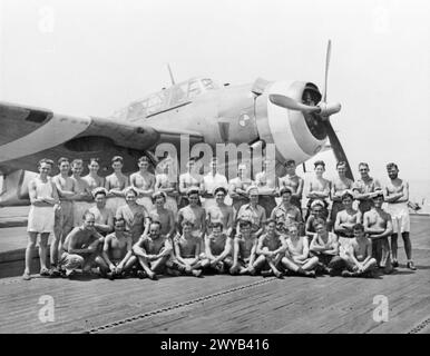 HOMMES D'UN PORTE-AVIONS D'ESCORTE BRITANNIQUE DANS LES EAUX D'EXTRÊME-ORIENT. MARS 1945, À BORD DU HMS EMPRESS. - Un groupe de Gallois servant dans l'IMPÉRATRICE devant un Avenger sur le pont d'envol. , Banque D'Images