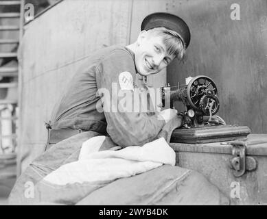 Signman May répare les drapeaux à bord du HMS Repulse lors de son radeau de 1940 en cale sèche alors que le navire est au port. Banque D'Images