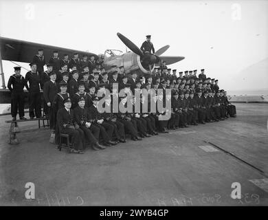 HOMMES DU 832E ESCADRON (BRAS AÉRIEN DE LA FLOTTE). 11 JANVIER 1942, À BORD DU HMS VICTORIOUS. - Officiers et hommes du 832e Escadron. De gauche à droite : première rangée : Sub Lieuts J A Barnes, P O'Shea, W H G Browne, d J Shepherd, l Brown, A J Hugill, G Child, R J Brown ; Lieut R C G de Longdeuil, RN ; Lieut J H Stennings, RN ; Lieut Cdr A J P Plugge, commandant de l'escadron, RN ; Lieut d W George, RAN ; lieuts sous-lieuts G J Conolley, R B Kingdon, C Friend, d B Shaw, G Evans, j d Lanoles, J F Fax, d Johnson ; et M. Knowler, représentant de Fairey. , Banque D'Images