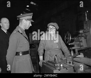 UNE VISITE ROYALE À THORP ARCH ROYAL ORDNANCE FACTORY, WETHERBY, YORKSHIRE, ANGLETERRE, ROYAUME-UNI, 1941 - SM King George VI parle à un travailleur des munitions à sa machine lors d'une visite à ROF Thorp Arch. , Banque D'Images