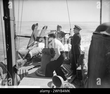 Un officier britannique et des instructeurs de classement observent un officier de marine français tirant un canon Oerlikon de 20 mm pendant l'entraînement pendant la seconde Guerre mondiale. Banque D'Images