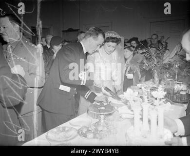 LE FILS DE L'AMIRAL ÉPOUSE LA FILLE D'EARL. 10 FÉVRIER 1944, MAISON DE L'AMIRAUTÉ. LORS DE LA RÉCEPTION EN PRÉSENCE DE LA PRINCESSE ELIZABETH ET DE LA PRINCESSE MARGARET, QUI A SUIVI LE MARIAGE À L'ABBAYE DE WESTMINSTER DU LIEUTENANT CHRISTOPHER WAKE-WALKER, RN, FILS DU VICE-AMIRAL SIR FREDERICK ET DE LADY WAKE-WALKER, ET DU TROISIÈME OFFICIER LADY ANNE SPENCER, WRNS, FILLE DU COMTE ET DE LA COMTESSE SPENCER. - La mariée et le marié coupent le gâteau. , Wake-Walker, Christopher Baldwin Hughes, Spencer, Anne Banque D'Images