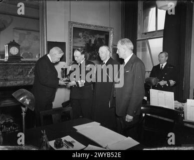 LA COUPE D'OR COMMÉMORE LE RÔLE DE LA NAVY À DUNKERQUE. MAI 1941, AMIRAUTÉ. UNE CÉRÉMONIE A EU LIEU À L'AMIRAUTÉ LORSQU'UNE COUPE D'OR A ÉTÉ REMISE PAR LORD QUEENBOROUGH, PRÉSIDENT DE LA ROYAL SOCIETY OF ST GEORGE, ET LORD WARDINGTON, PREMIER DIRECTEUR DE LA COMPAGNIE DES ORFÈVRES, AU VICE-AMIRAL JH D CUNNINGHAM, CB, MVO, QUATRIÈME LORD SEA, ET SIR J. SIDNEY BARNES SOUS-SECRÉTAIRE DE L'AMIRAUTÉ, REPRÉSENTANT LE CONSEIL D'ADMINISTRATION DE L'AMIRAUTÉ. LA COUPE A ÉTÉ MISE AUX ENCHÈRES CHEZ CHRISTIES À L'AIDE DE LA CROIX ROUGE, UNE CONDITION DE LA VENTE ÉTANT QUE LA COUPE DOIT, APRÈS LA VENTE, ÊTRE PRÉSENTÉE À L'AMIRAUTÉ ET QU'ELLE Banque D'Images