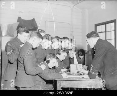 BRITISH AIRCRAFT TRAINING CORPS. LES GARÇONS VISITENT UNE STATION AÉRIENNE DE LA ROYAL NAVY 18 JANVIER 1942, STATION AÉRIENNE DE LA ROYAL NAVY DONIBRISTLE. CHAQUE DIMANCHE, LORSQUE LES CIRCONSTANCES LE PERMETTENT, LES GARÇONS DE L'ATC DES VILLES VOISINES VISITENT LA ROYAL NAVY AIR STATION. - Faire accélérer leur morse. Les garçons de l'ATC s'entraînent sur la clé Morse d'un instructeur. , Banque D'Images