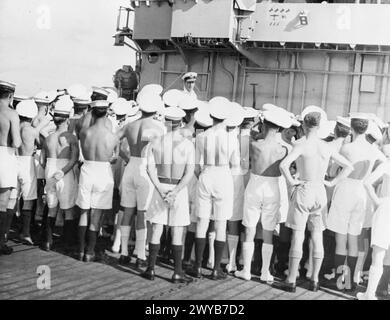 AVEC LE PORTE-AVIONS D'ESCORTE HMS EMPRESS À L'EST. JUILLET ET AOÛT 1945, À BORD DU HMS EMPRESS. DES SCÈNES DE CÉLÉBRATION NOCTURNES AVEC LA FLOTTE BRITANNIQUE DES INDES ORIENTALES À TRINCOMALEE LA NUIT DE VJ, ET DES PHOTOS OPÉRATIONNELLES JUSTE AVANT LA REDDITION JAPONAISE. - En juillet, lorsque l'amiral Lord Louis Mountbatten a rendu visite à l'IMPÉRATRICE et s'est adressé à la compagnie du navire sous la structure de l'île qui porte son fier bilan d'opérations réussies. , Banque D'Images