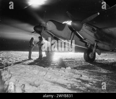 ROYAL AIR FORCE : 2ND TACTICAL AIR FORCE, 1943-1945. - L'Adjudant d Gosling (à gauche) et le chef d'escadron G H Hayhurst du No. 604 Squadron RAF, se tiennent devant leur de Havilland Mosquito NF Mark XII dans la neige à B51/Lille-Vendeville, France, avant de décoller pour une sortie de chasse de nuit. , Royal Air Force, maintenance Unit, 64, Royal Air Force, unité de maintenance, 201 Banque D'Images