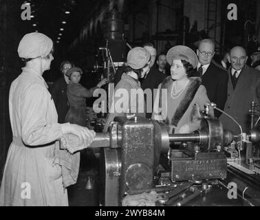 UNE VISITE ROYALE À THORP ARCH ROYAL ORDNANCE FACTORY, WETHERBY, YORKSHIRE, ANGLETERRE, ROYAUME-UNI, 1941 - sa Majesté la Reine Elizabeth parle aux travailleurs des munitions à leurs machines lors d'une visite à ROF Thorp Arch. , Elizabeth, Reine Banque D'Images