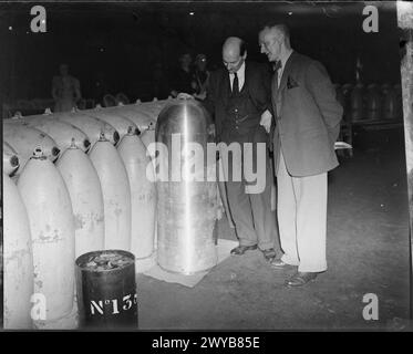 CLEMENT ATTLEE VISITE L'USINE DE FABRICATION DE MUNITIONS ROYAL HEREFORD, HEREFORDSHIRE, ANGLETERRE, Royaume-Uni, JUILLET 1941 - Lord Privy Seal, M. Clement Attlee, examine une ogive de torpille lors d'une visite à ROF Hereford le vendredi 11 juillet 1941. , Attlee, Clement Richard Banque D'Images