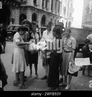 Les internés britanniques achètent des journaux à leur arrivée à Hong Kong après avoir quitté le camp d'internement civil de Stanley pendant la libération et le rapatriement, août-septembre 1945. Banque D'Images
