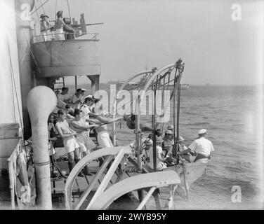 DEUX ANS AVEC LE HMS BUTSER ET AUCUN SIGNE DE L'ENNEMI. JANVIER 1944, FREETOWN. LE HMS BUTSER, UN CHALUTIER ANTI-SOUS-MARIN DE 600 TONNES, EST UN EXEMPLE TYPIQUE DES NOMBREUX PETITS NAVIRES ACTUELLEMENT EN SERVICE AVEC UN RECORD DE DUR LABEUR SANS SOULAGEMENT PAR LA STIMULATION DE L'ACTION CONTRE L'ENNEMI. - Même dans le port, les hommes de BUTSER sont tenus vigilants et sur leurs orteils par un devoir d'exercice constant. Ici, l'embarquement du navire s'en va comme s'ils interceptaient un navire suspect en mer. , Banque D'Images