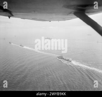 L'AUGUSTA ET SON ESCORTE DANS LA MANCHE. 14 JUILLET 1945, PHOTOGRAPHIE AÉRIENNE, APPROCHE DES DESCENTES. LE CROISEUR AMÉRICAIN AUGUSTA, TRANSPORTANT LE PRÉSIDENT TRUMAN À LA GRANDE RÉUNION DES TROIS, S'EST APPROCHÉ DES DOWNS AVEC SON ESCORTE DU CROISEUR BRITANNIQUE HMS BIRMINGHAM ET DES DESTROYERS HM SERAPIS, OBDURÉ, OBÉISSANT, ZÉLÉ, ZEPHYR, ET LE ZODIAC, ET LE CROISEUR AMÉRICAIN PHILADELPHIA. - Une partie de l'escorte d'AUGUSTA. De gauche à droite : HMS SERAPIS, HMS BIRMINGHAM, le croiseur américain PHILADELPHIA, le HMS OBEDIENT et le HMS ZEALOUS. , Banque D'Images