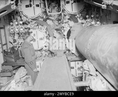 LES SOUS-MARINIERS BRITANNIQUES INSPECTENT LE U-BOOT ALLEMAND RENDU. 24 MAI 1945, KIEL. - Le lieutenant P C Chapman, DSO, DSC et le bar, RN, de Ealing (centre en haut) inspectant la salle des torpilles des U-Boot avec, de gauche à droite : le CPO W Freeman, TGM, d'Exeter ; PO WM Richardson, TGM, de Newcastle-on-Tyne, et CEA E Rintoul, de Chatham, Kent. , Banque D'Images