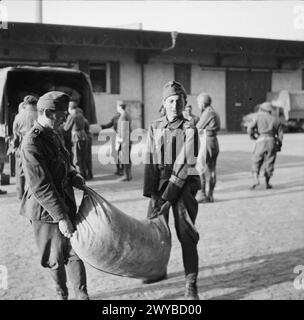 Les soldats allemands déchargent des vivres d'urgence à Bergen-Belsen, en avril 1945, répondant au besoin critique de nourrir les anciens détenus immédiatement après la libération. Banque D'Images