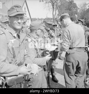 LE DÉSARMEMENT DES TROUPES ALLEMANDES TRAVERSANT LA FRONTIÈRE DANOISE EN ALLEMAGNE - soldat britannique vérifiant les carnets d'identité des soldats allemands au poste frontière de Krusau. , Armée allemande (troisième Reich) Banque D'Images