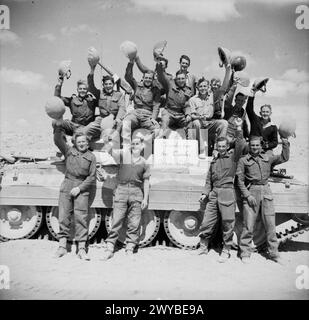 Les équipages de l'armée britannique posent avec un char Crusader en Afrique du Nord le 2 avril 1942, affichant une pancarte remerciant la Grande-Bretagne d'avoir fourni des chars pendant la campagne en Libye. Banque D'Images