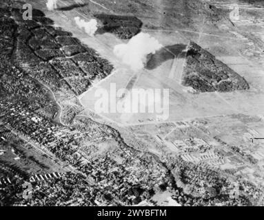 BOMBARDEMENT DE PRÉCISION PAR LES CHASSEURS DE LA FLOTTE DES INDES ORIENTALES BRITANNIQUES. JUIN 1945. PHOTOGRAPHIES DE L'UN DES CHASSEURS HELLCAT PARTICIPANT AU RAID DE BOMBARDEMENT SUR L'AÉRODROME DE MEDAN DANS LE NORD DE SUMATRA. - Bombes larguées par des avions de la marine qui explosent le long de la piste de l'aérodrome japonais de Medan. , Banque D'Images