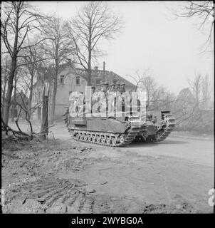 Un char Churchill de la 6e brigade de chars de la Garde britannique transporte des parachutistes de la 17e division aéroportée américaine en Allemagne le 29 mars 1945 lors d'opérations dans le Nord-Ouest de l'Europe. Banque D'Images