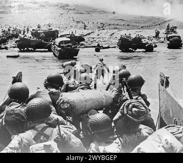 JOUR J - FORCES ALLIÉES PENDANT L'INVASION DE LA FRANCE 6 JUIN 1944 - les troupes de suivi de la 1re division d'infanterie américaine débarquent d'un LCVP (Landing Craft, Vehicle, personnel) sur Easy Red Beach, région d'Omaha, le 6 juin 1944. Des DUKW et des demi-chenilles remorquant des canons de 57 mm peuvent être vus en arrière-plan. , Banque D'Images