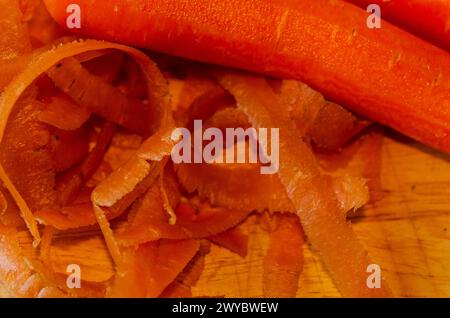 Carottes biologiques pelées sur une planche à découper en bois Banque D'Images