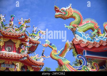 Sculptures de dragon colorées et complexes ornant le toit d'un temple traditionnel taïwanais contre un ciel clair Banque D'Images