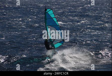 Planche à voile bleue contre l'océan Atlantique bleu scintillant au soleil (île de Tenerife, Espagne) Banque D'Images