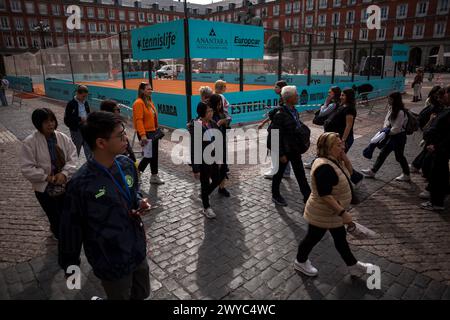 Madrid, Espagne. 05th Apr, 2024. Les touristes marchent à côté d'un court de tennis installé sur la Plaza Mayor de Madrid. Un court de tennis est installé sur la Plaza Mayor de Madrid pour promouvoir le tournoi Mutua Madrid Open 2024, réunissant les meilleurs joueurs de tennis du monde, qui se tiendra à Madrid du 22 avril au 5 mai à la Caja Magica. Crédit : SOPA images Limited/Alamy Live News Banque D'Images