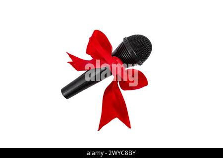 Microphone noir avec noeud en ruban de satin rouge sur fond blanc festif Banque D'Images