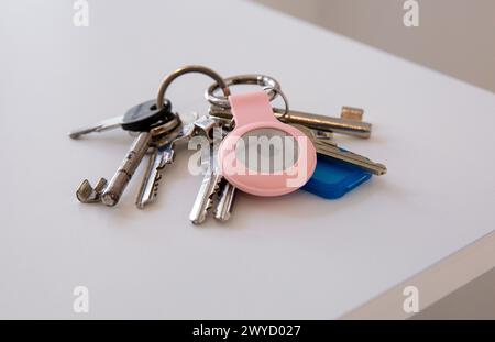 Gros plan des clés avec un AirTag pomme sur la table blanche Banque D'Images