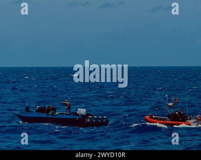 Des membres d'équipage de l'USCGC Margaret Norvell (WPC 1105) effectuent un arraisonnement des forces de l'ordre à bord d'un navire de contrebande de drogue situé à environ 190 milles au sud de Porto Rico le 24 mars 2024. L'équipe d'embarquement de la Garde côtière a appréhendé cinq contrebandiers présumés et a localisé plus de 1 850 livres de cocaïne d'une valeur marchande estimée à environ 24,3 millions de dollars. (Photo de la Garde côtière américaine avec l'aimable autorisation de l'équipage Margaret Norvell de l'USCGC) Banque D'Images