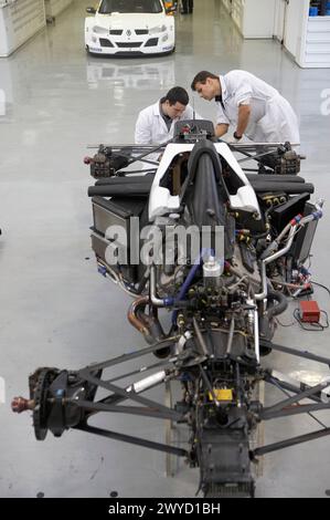 Mécaniciens travaillant sur les voitures de course, les World Series, la formule 3000. Epsilon Euskadi, centre de haute performance technique automobile, Azkoitia, Gipuzkoa, pays Basque. Banque D'Images