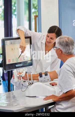 Thérapeute et patient avec robot d’assistance pour la rééducation des membres supérieurs, le robot ArmAssist permet un entraînement passif, assisté et actif du bras et de la main, permettant le traitement de la plupart des patients atteints d’AVC. Dispositif médical pour traitement neurologique. La plate-forme logicielle permet une évaluation à distance des progrès du patient et une gestion de la thérapie basée sur des jeux sérieux, qui motivent les patients à participer activement à leur rééducation et à maximiser. The Outcome, unité de technologie de la santé, Tecnalia Research & innovation, Adacen, Centre de traitement et de réadaptation des lésions cérébrales, M. Banque D'Images