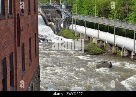 SHERBROOKE, QUÉBEC, CANADA - 6 MAI 2022 - rivière Magog barrage de la centrale hydroélectrique Sherbrooke Abenakis. Grande conduite forcée blanche et passerelle Banque D'Images