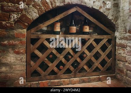 Cave à vin dans une ancienne maison sous-sol. Différentes bouteilles sont stockées dans une pièce. Les étagères sont pleines de boissons alcoolisées. Style de vie gastronomique à la maison Banque D'Images