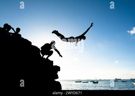 Salvador, Bahia, Brésil - 31 mai 2019 : un jeune homme, en silhouette, est vu sauter de la jetée de Porto da Barra dans la ville de Salvador, Bahia. Banque D'Images