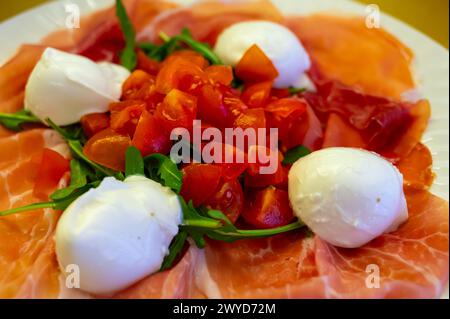 Cuisine de la région Emilie-Romagne, salade Caprese avec Prosciutto crudo, prosciutto di Parma, mozzarella et tomates, déjeuner à Parme, Italie Banque D'Images