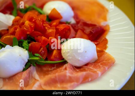 Cuisine de la région Emilie-Romagne, salade Caprese avec Prosciutto crudo, prosciutto di Parma, mozzarella et tomates, déjeuner à Parme, Italie Banque D'Images