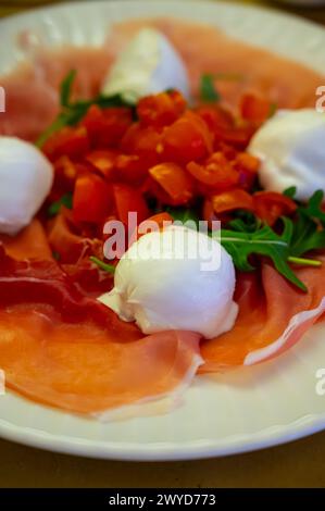 Cuisine de la région Emilie-Romagne, salade Caprese avec Prosciutto crudo, prosciutto di Parma, mozzarella et tomates, déjeuner à Parme, Italie Banque D'Images