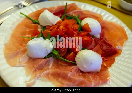 Cuisine de la région Emilie-Romagne, salade Caprese avec Prosciutto crudo, prosciutto di Parma, mozzarella et tomates, déjeuner à Parme, Italie Banque D'Images