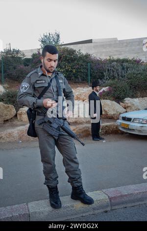 12-25-2014 Jérusalem . Soldat de l'armée israélienne en vacances à l'arrêt de bus ou arrêt de tram. (Aussi les gens Ther et juif orthodoxe) Banque D'Images