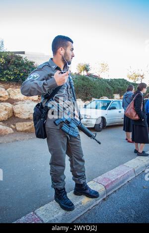 12-25-2014 Jérusalem . Soldat (en vacances) avec mitrailleuse (TAR-21) de l'armée israélienne en vacances à l'arrêt de bus ou de tram. (également people on Banque D'Images