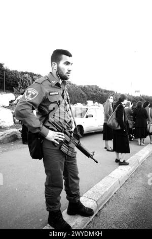 12-25-2014 Jérusalem . Soldat (en vacances) avec mitrailleuse (TAR-21) de l'armée israélienne en vacances à l'arrêt de bus ou de tram. (également people on Banque D'Images