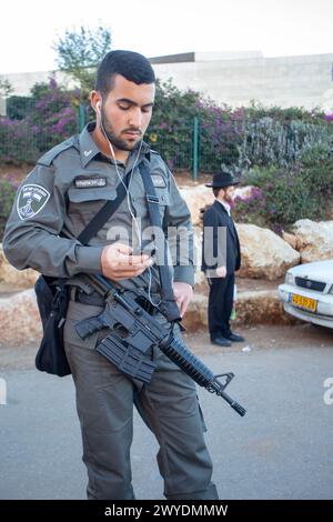 12-25-2014 Jérusalem . Soldat (en vacances) avec mitrailleuse (TAR-21) de l'armée israélienne en vacances à l'arrêt de bus ou de tram. (également people on Banque D'Images