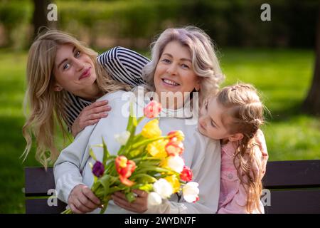 Famille de trois générations avec bouquet de tulipes. Banque D'Images
